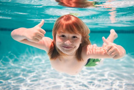 Téléchargez les photos : Underwater child swims in pool, healthy child swimming and having fun under water. Summer vacation - en image libre de droit