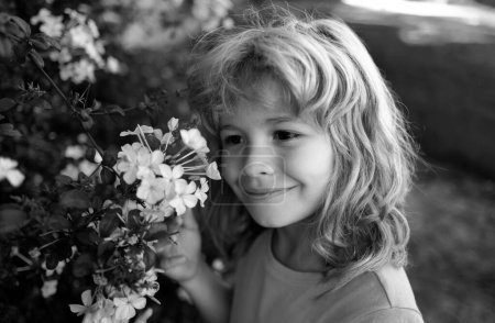 Photo for Outdoor small child portrait on the meadow. Little cute kid with flowers in a garden. Children play outdoors. Kid play outdoor. Concept of happy childhood and summer leisure - Royalty Free Image