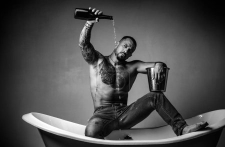 Sexy undress man sit on bathtub in bathroom, men holiday with champagne. Celebrating christmas or birthday. Private sex party