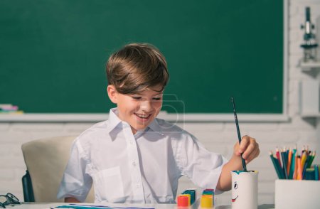 Foto de Child boy drawing cute draw using colored pencils at school or kindergarten. Childhood learning, kids artistics skills - Imagen libre de derechos