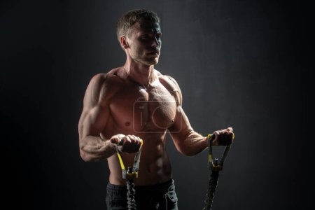 Photo for Strong man exercising suspension training trx. Sexy muscular man doing suspension training. Sport. Men training with fitness trx straps in gym. Guy exercising her muscles sling or suspension straps - Royalty Free Image