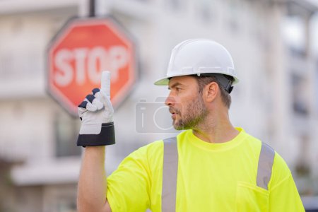 Foto de Constructor con gesto de stop, sin mano, peligroso en el concepto de construcción. Hombre con casco mostrando señal de stop road. Constructor mostrando stop - Imagen libre de derechos