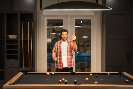Photo for The billiard. Guy Playing billiards. Man hit ball in billiard in Billiard room. Russian pool billiards. Snooker Player. Young professional man playing billiards in the dark billiard club - Royalty Free Image