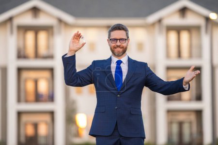 Photo for Real estate agent in suit hold money dollars and keys on new house. Special offer. Business deal. Job offer, Purchase offer. Discount offer - Royalty Free Image