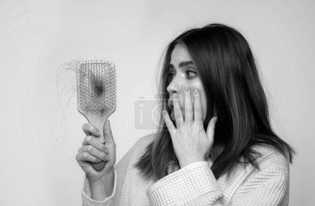 Téléchargez les photos : Femme main tenant peigne avec grave problème de perte de cheveux pour shampooing de soins de santé - en image libre de droit