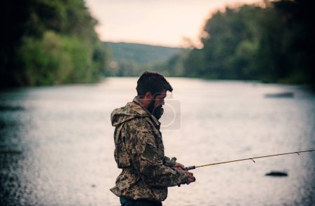 Téléchargez les photos : Homme avec canne à pêche, pêcheurs en plein air dans l'eau de la rivière. Passe-temps de pêche de printemps - en image libre de droit