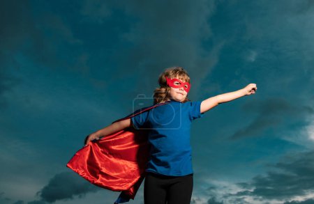 Foto de Chico superhéroe contra el dramático fondo del cielo azul. Fuerte superhéroe chico con superpoder - Imagen libre de derechos
