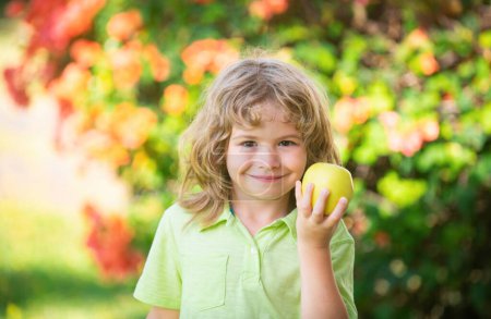 Foto de Pequeño niño lindo comiendo manzana verde. Retrato de un niño comiendo y mordiendo una manzana. Disfruta el momento de comer. Comida saludable y concepto de niño - Imagen libre de derechos
