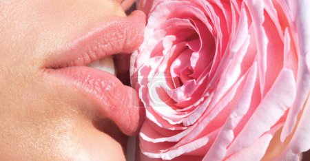 Foto de La ternura subió. Labios naturales tiernos con rosa rosada. Ternura boca de mujer sexy. Cuidado y ternura. Close-up hermosos labios tiernos con flor de rosa rosa. Spa y cosméticos. Tacto de ternura - Imagen libre de derechos