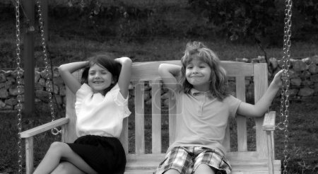 Foto de Portrait of brother and sister in summer park outdoors. Little boy and girl kids enjoying summer at backyard. Best friends of two children - Imagen libre de derechos