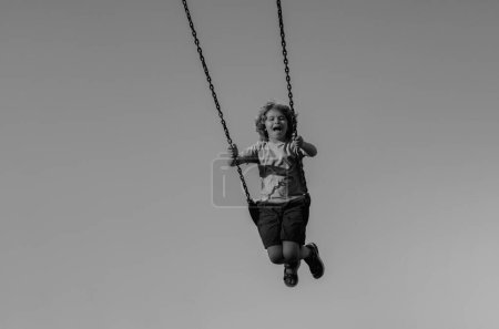 Photo for Joyful kid swinging on a swing. Happiness children. Child extreme swinging. Danger high Swing in sky. Craziness and freedom. Kid playing on swing-set outdoor. Playful child swinging very high to the - Royalty Free Image