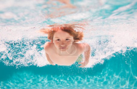 Foto de Niño nadando bajo el agua en la piscina. Agua de mar azul. Niño nadando en el mar. Vacaciones infantiles y concepto de vacaciones de verano - Imagen libre de derechos