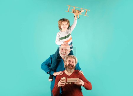 Día de los Padres. Chico divirtiéndose con avión de juguete. Familia de la generación de los hombres con tres generaciones diferentes edades abuelo padre e hijo