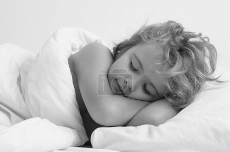 Photo for Kid sleeping in cozy white bed. Kid sleeping on bed at home. Bedtime, kids sleeps. Child asleep on pillow, having healthy sleep - Royalty Free Image
