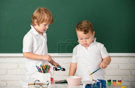 Photo for Children boys brothers drawing cute draw using colored pencils at school or kindergarten. Kids art, creativity children concept - Royalty Free Image