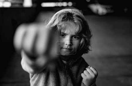 Foto de Pelea de niños agresiva. Un niño peleando afuera. Un niño enojado mostrando su puño. Retrato del chico de la pelea. Acoso, abuso físico, peleas de niños. Un niño agresivo. Niños mal comportamiento - Imagen libre de derechos