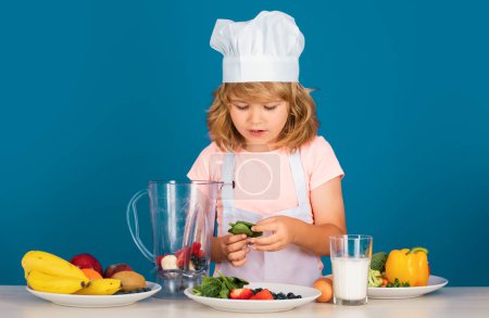 Photo for Portrait of chef child in cook hat. Cooking at home, kid boy preparing food from vegetable and fruits. Healthy eating - Royalty Free Image