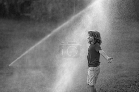 Photo for Child playing at summer backyard. Water fun in garden. Kid play with water sprinkler in garden. Funny little boy playing with garden watering hose in yard. Child having fun with spray of water - Royalty Free Image