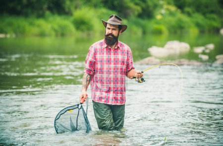 Foto de Fisherman man on river or lake with fishing rod - Imagen libre de derechos