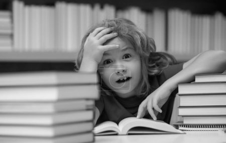 Photo for Surprised school kid. Kid on school library. Child reading book at school. Nerd pupil studying in classroom. Clever intelligent schoolboy overwork. Smart child learning to read book. Hard study - Royalty Free Image