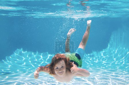 Foto de Chico submarino en la piscina. Niño lindo nadando en la piscina bajo el agua. Actividades de verano para niños, deportes acuáticos - Imagen libre de derechos