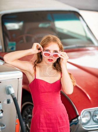 Photo for American woman, girl. Retro Girl with Car. Gas station, woman refuel the auto. Red retro automobile - Royalty Free Image