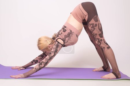 Téléchargez les photos : Yoga girl concept. Fit femme pose pour un portrait après l'entraînement. Plan studio d'une jeune femme en forme faisant des exercices de yoga - en image libre de droit