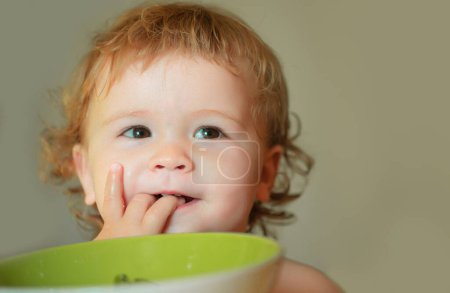 Photo for Smiling baby eating food. Healthy nutrition for kids. Funny child face closeup - Royalty Free Image