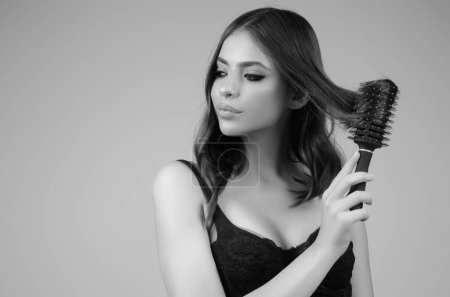 Téléchargez les photos : Beautiful woman with brush combing hair. Beauty girl with straight hair isolated on studio background. Woman hold hairbrush near face. Healthy hair. Hairstyle and hair care concept. Shiny hairs - en image libre de droit
