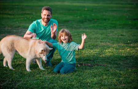 Foto de Feliz padre e hijo con perro en el parque. Actividad de fin de semana feliz concepto de estilo de vida familiar - Imagen libre de derechos