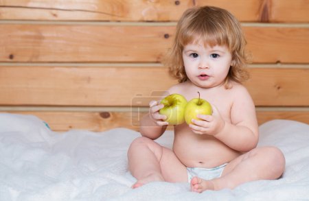 Téléchargez les photos : Bébé mignon manger des pommes. Nourriture solide pour bébé. Alimentation des enfants, concept nutritionnel - en image libre de droit