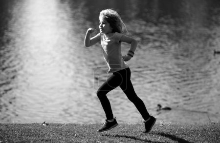 Foto de Niño corriendo al aire libre. Corredor de niños corriendo en la naturaleza. Correr por la mañana. Estilo de vida activo para niños sanos. Correr ayuda al cuerpo a ser fuerte - Imagen libre de derechos