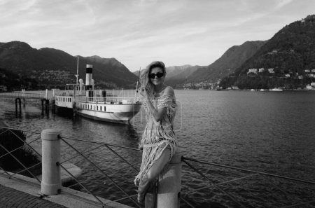 Téléchargez les photos : Femme sexy en robe de mode sexy profitant de la vue sur le lac de Côme en Italie. Voyager à l'étranger en Europe. Voyagez le week-end. Concept de voyage d'été. Femme sexy - en image libre de droit