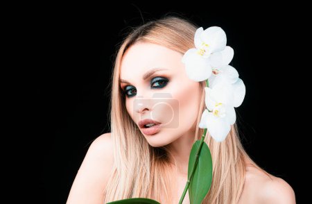 Téléchargez les photos : Portrait de beau modèle avec maquillage nu naturel. Mode et beauté. Femme avec des fleurs - en image libre de droit