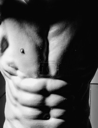Foto de Cerca del pecho masculino. Músculos torácicos. Torso muscular masculino con abdominales. Athletic Man mostrando cuerpo musculoso y seis abdominales. Muchacho. concepto de topless sin camisa - Imagen libre de derechos