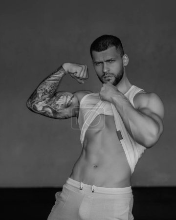 Photo for Sexy and naked muscular young man posing indoors. Sexy shirtless male model. Attractive young naked man. Sexy male body. Young muscular male modelposing with sexy body. Bare torso - Royalty Free Image