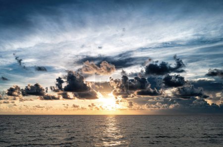 Foto de Puesta de sol en la playa tropical mar océano con nubes del amanecer. Banner para vacaciones de viaje. Paisaje cielo y reflejos rayos en el agua. Crepúsculo, crepúsculo en el mar. Tranquilo, fondo dorado del cielo - Imagen libre de derechos