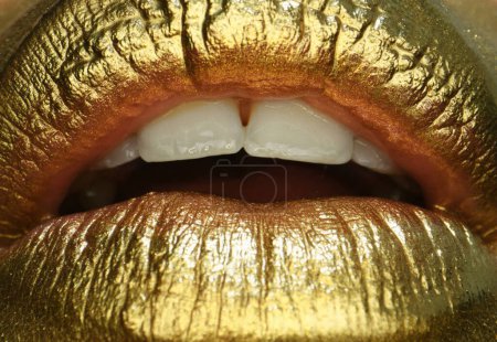 Téléchargez les photos : Cosmétique glamour. Des lèvres d'or. Peinture dorée de la bouche. Lèvres dorées sur la bouche de la femme avec maquillage. Design sensuel et créatif pour métal doré - en image libre de droit