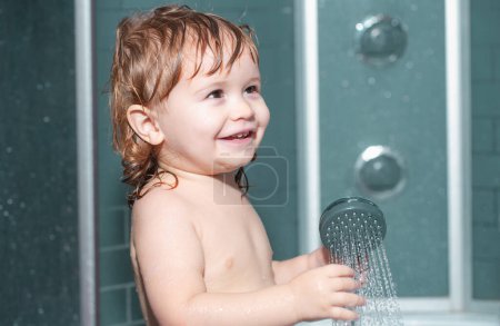 Téléchargez les photos : Santé des enfants. Bébé heureux prenant un bain jouant avec des bulles de mousse. Petit enfant dans une baignoire. Enfant souriant dans la salle de bain. Lavage et bain des nourrissons. Soins et hygiène des enfants - en image libre de droit