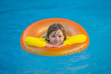 Téléchargez les photos : Nager, vacances d'été. Enfant nager dans la piscine sur anneau gonflable. Enfant avec anneau gonflable dans la piscine. Vacances d'été. Enfant dans la piscine. Enfant flottant dans l'eau de mer - en image libre de droit