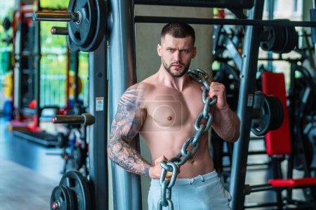 Photo for Fit guy doing exercise at gym. Handsome sporty man workout with with dumbbells on gym. Male athlete with dumbbell on fitness workout. Fitness man in gym. Muscular sportsman workout with weight in gym - Royalty Free Image
