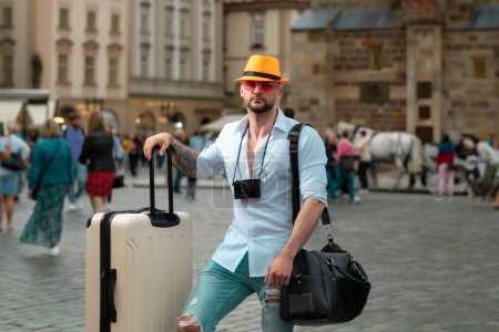 Foto de Turista de vacaciones. Hombre turista viajero en ropa casual con maleta. Viajar al extranjero los fines de semana. Concepto de viaje - Imagen libre de derechos