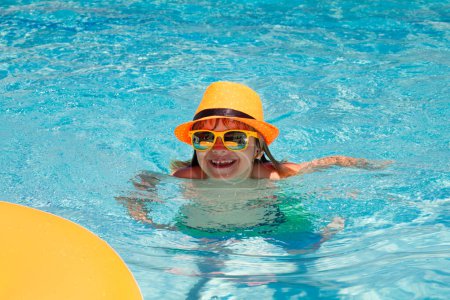 Téléchargez les photos : Amusant. Enfant nageant sur anneau flottant dans la piscine. Portrait d'été enfant - en image libre de droit