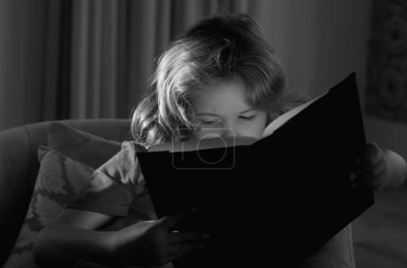 Photo for Close up portrait of cute blonde child reading interesting kids book story. Kid read book at home - Royalty Free Image