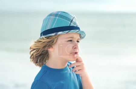 Photo for Little boy in summer sunglasses and hat on sea beach. Kid on summer vacation. Kids dreaming face. Outdoor closeup portrait of funny kids face. Summer kid outdoor portrait. Close up face of cute child - Royalty Free Image