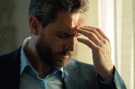 Kopfschmerzen, Müdigkeit und Stress. Nahaufnahme Porträt des Mannes im Anzug bekam Kopfschmerzen Migräne. Kopfschmerzkonzept. Schmerzhafte Männer sind bei der Arbeit im Büro gestresst. Stress und Kopfschmerzen