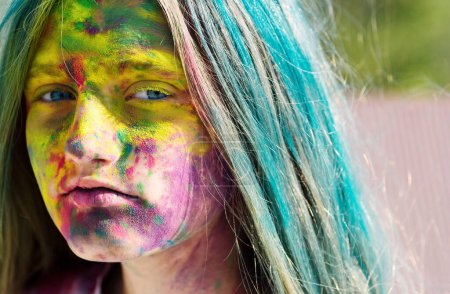 Dry color on face. Colorful holi on painted hair and face. Girls with colorful hair and face enjoing in the moment. Dry color concept. Happy life in teenager time