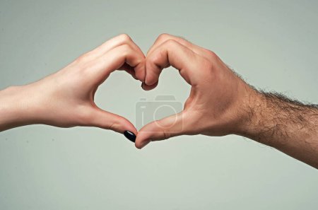 Téléchargez les photos : Coeur des mains. Amour, concept d'amitié. Homme et femme, main dans le cœur, forment l'amour. Signez coeur par doigts. Amour le jour de la Saint-Valentin. Deux hommes tiennent la main gestuelle symbole de la forme du cœur. Un signe d'amour. Organisme de bienfaisance - en image libre de droit