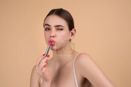 Photo for Sexy girl use lipstick, background beauty and fashion, lips appreciation concept. Plump woman lips, isolated on beige studio background - Royalty Free Image