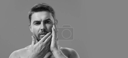 Photo for Closeup portrait of attractive man with cream on face. Beautiful man close up portrait on white background. Banner for header, copy space. Poster for web design - Royalty Free Image